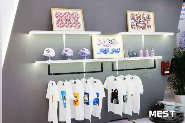 Display of DTF-printed apparel and promotional gift samples at the MEST Print showroom. Display of DTF-printed apparel and promotional gift samples at the MEST Print showroom.